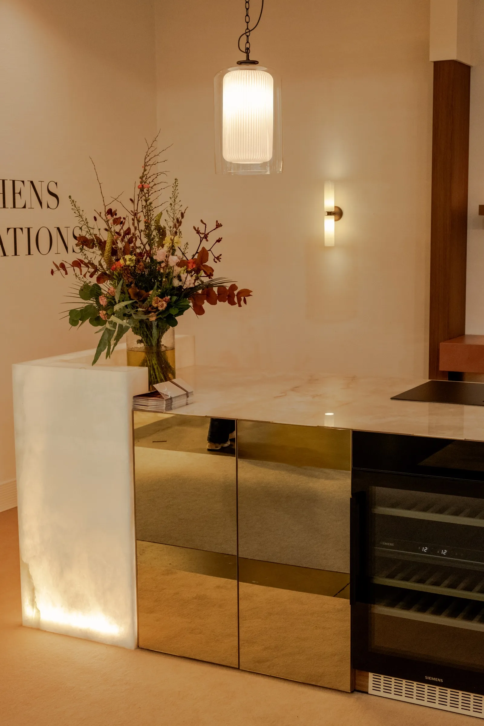 Keukeneiland van doorschijnend steen met een bloemstuk en een wandlamp