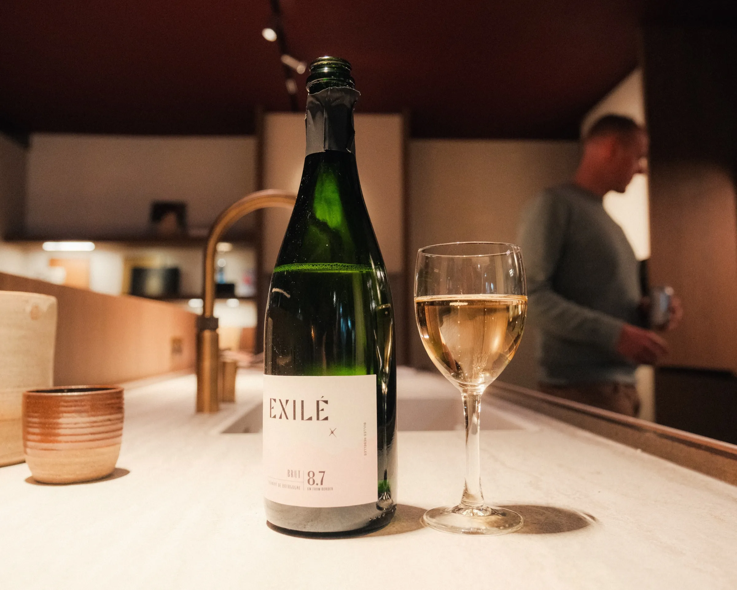 Fles wijn en een glas op een verlichte toog