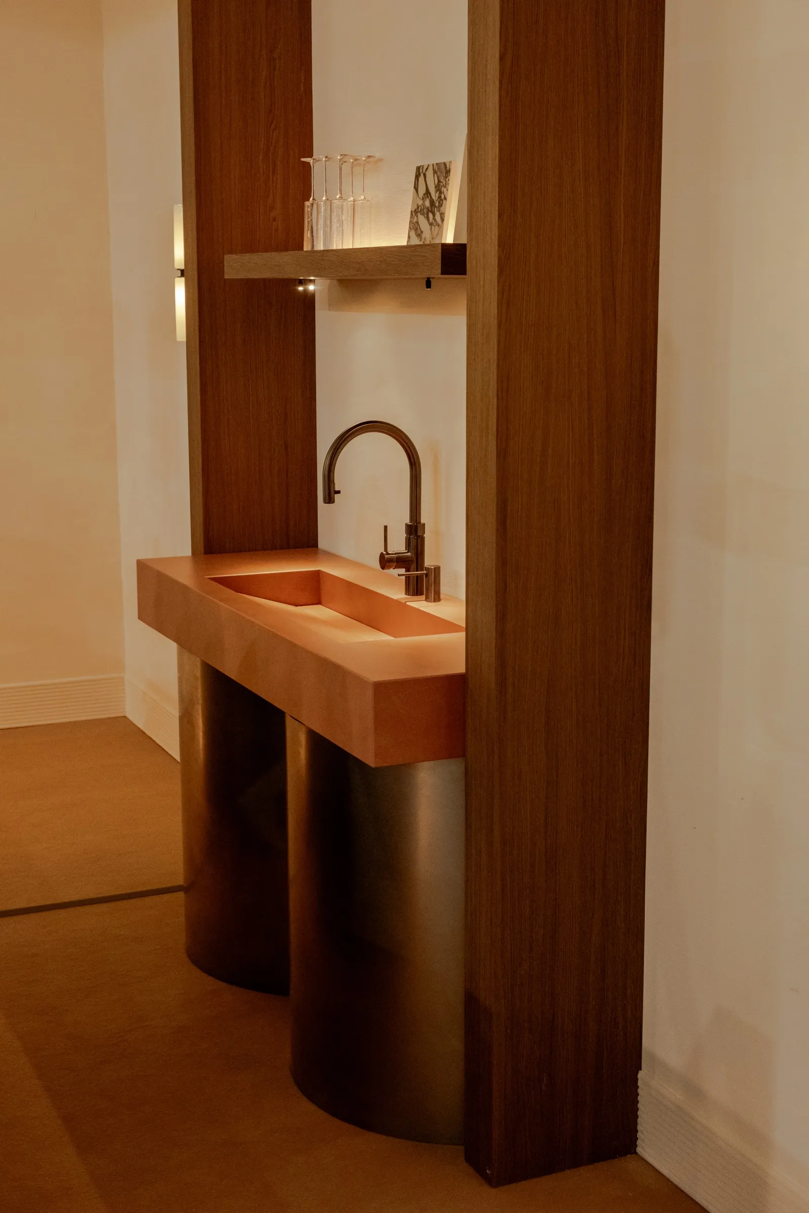 Koperen wasbak tussen twee houten wanden