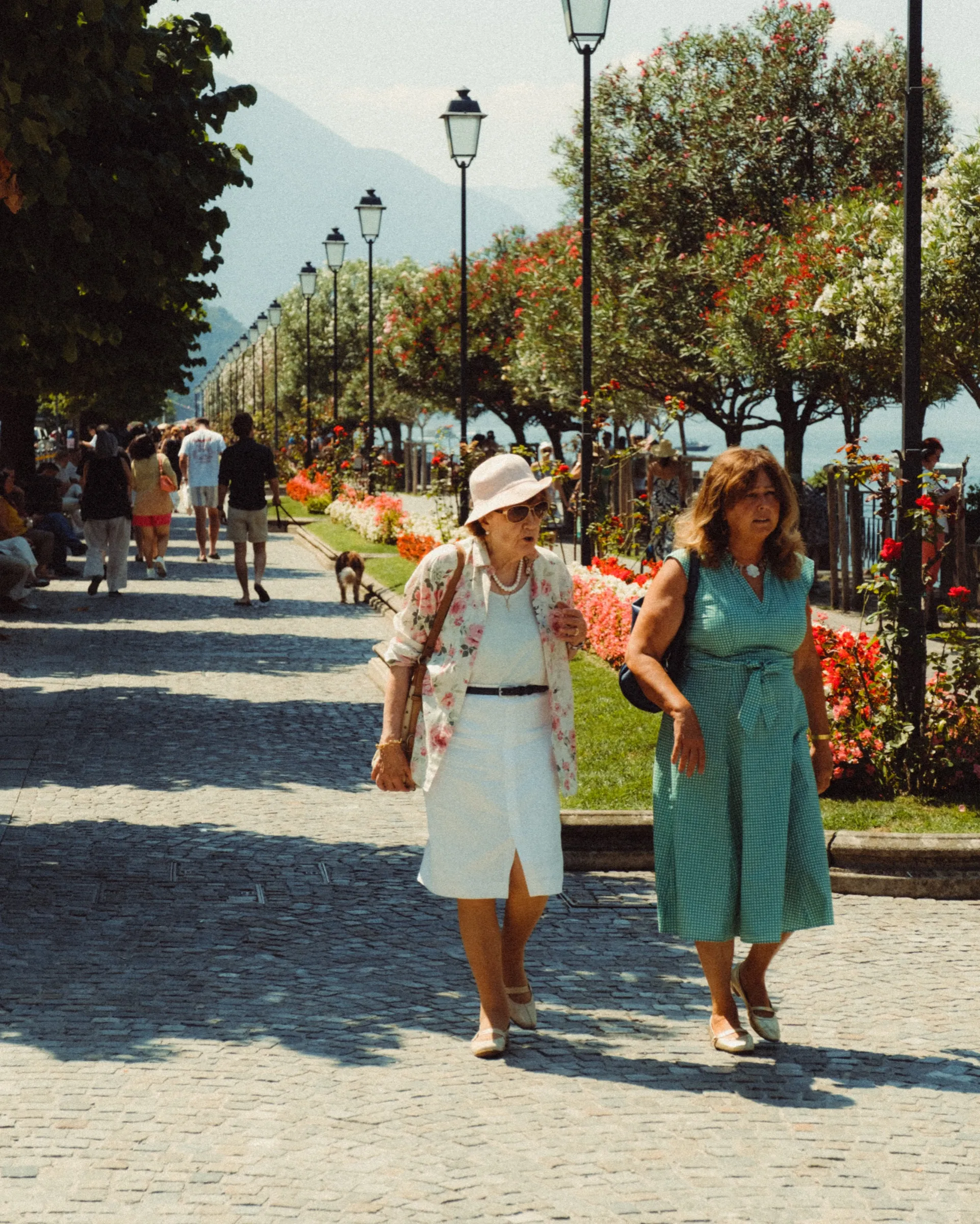 Twee vrouwen wandelen over de promenade langs het meer