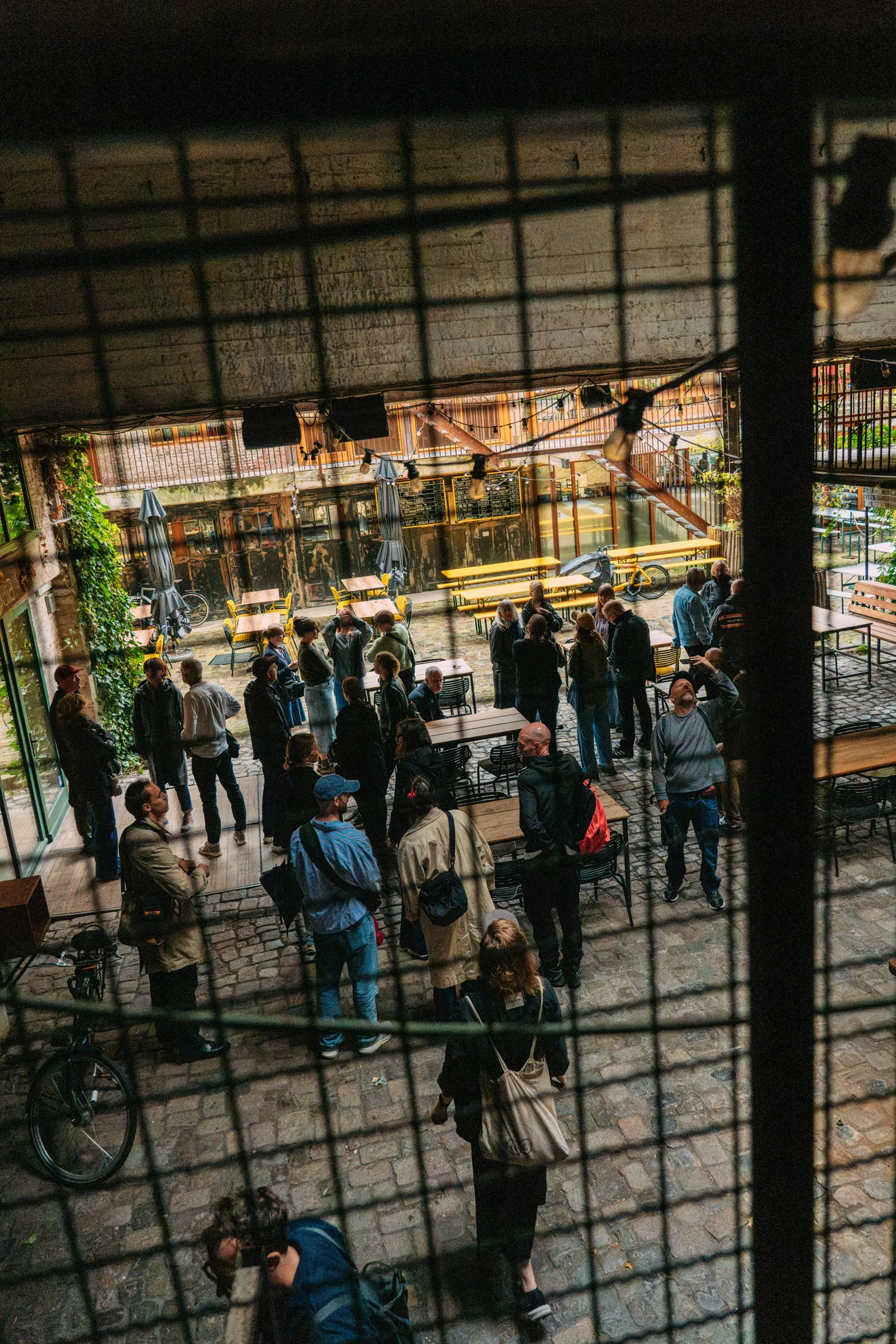 De groep verzamelt onder een glazen overkapping van een binnenplaats