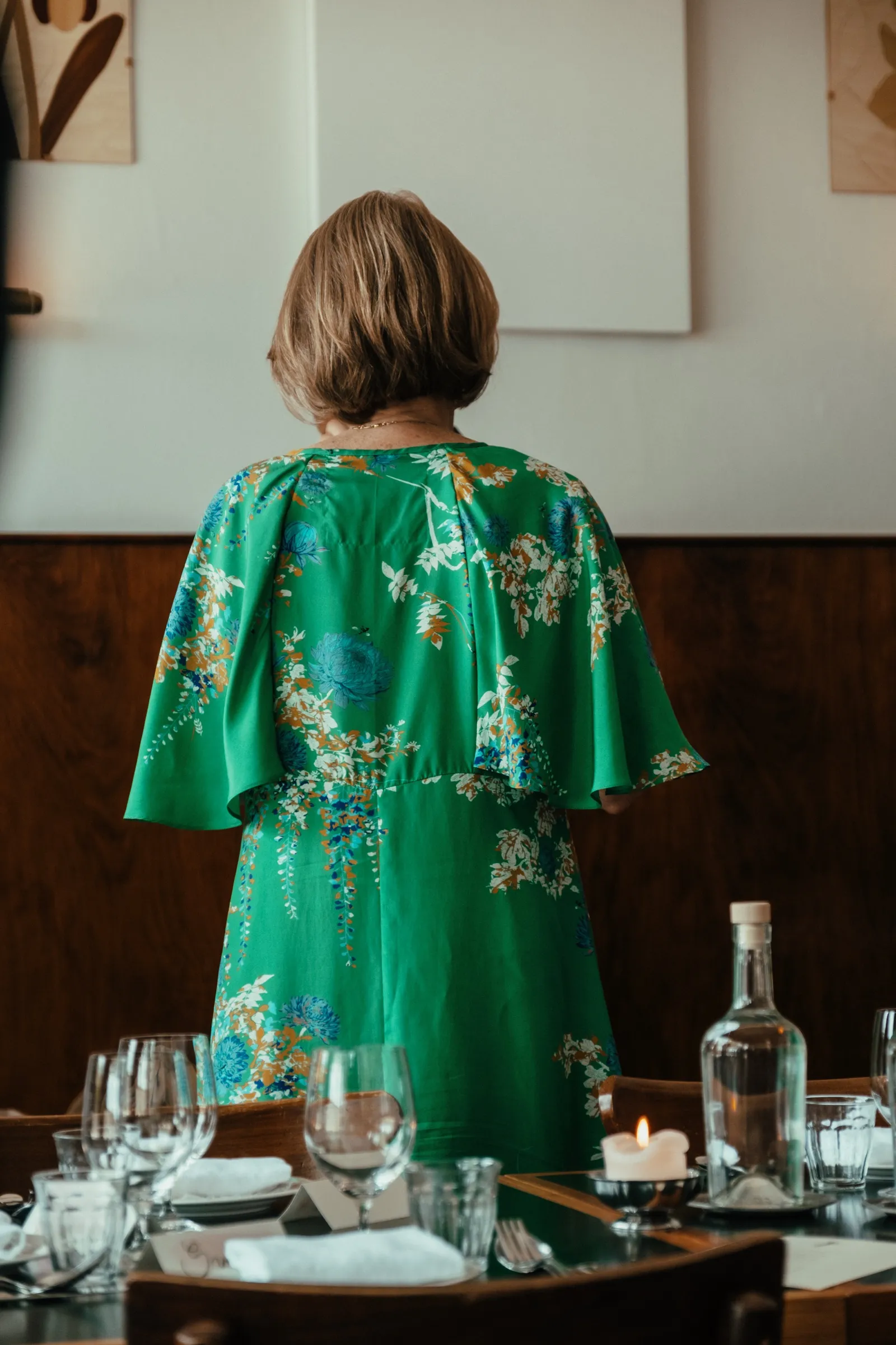 Een gast in een groene kimono, van achteren