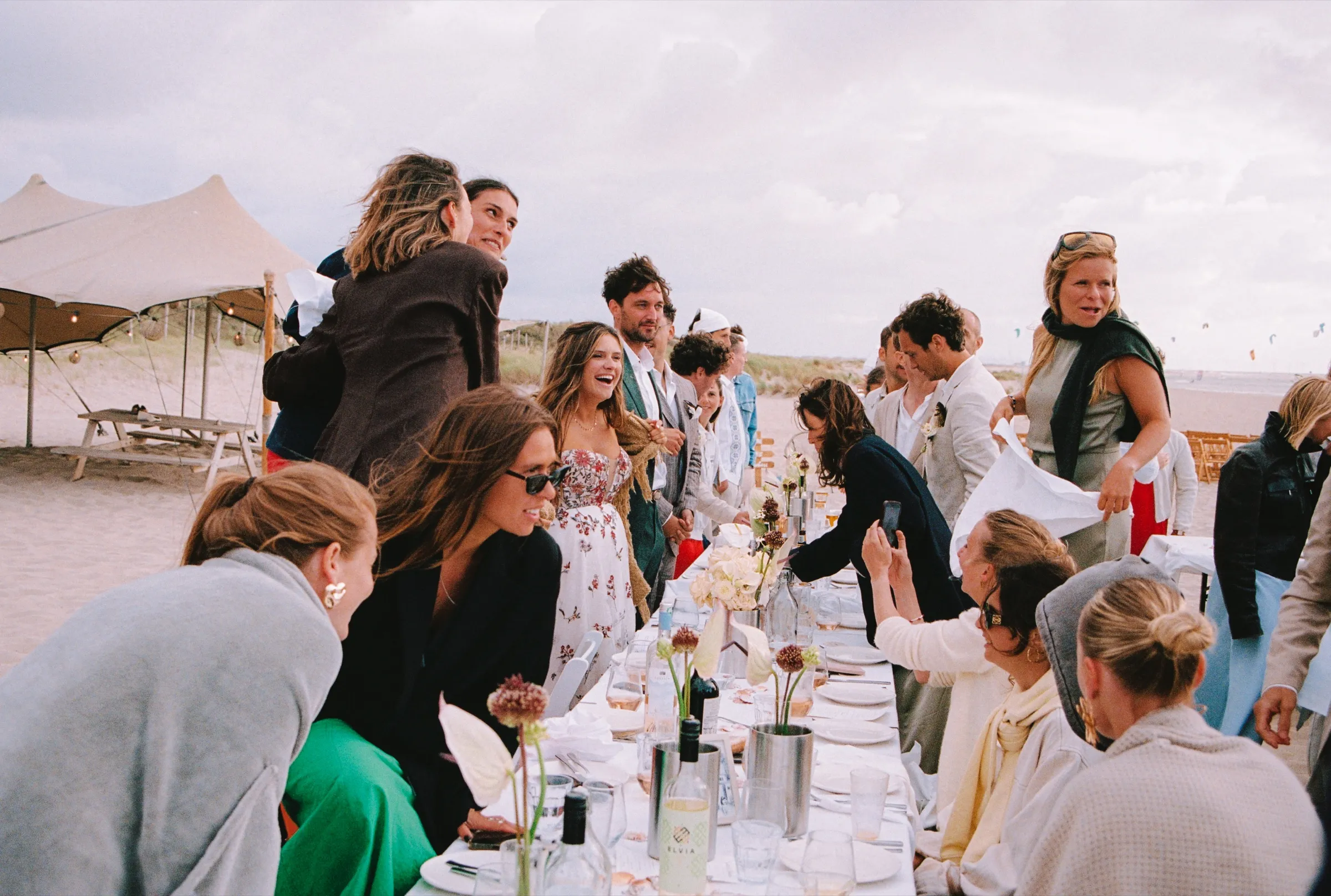 Gasten leunen naar elkaar aan de lange tafel
