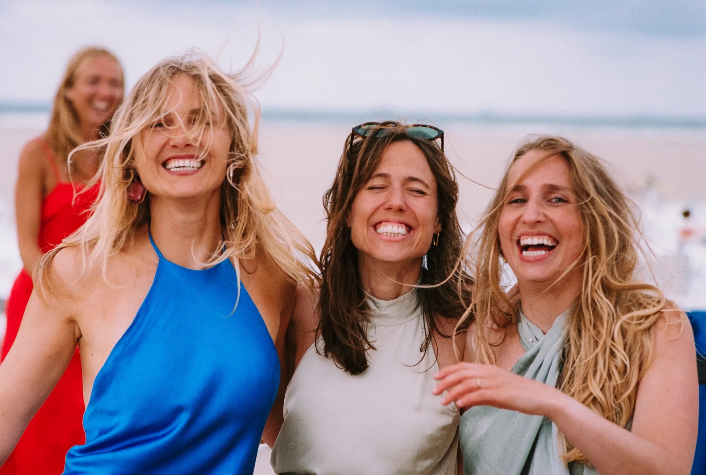 Drie vriendinnen lachen met wapperend haar
