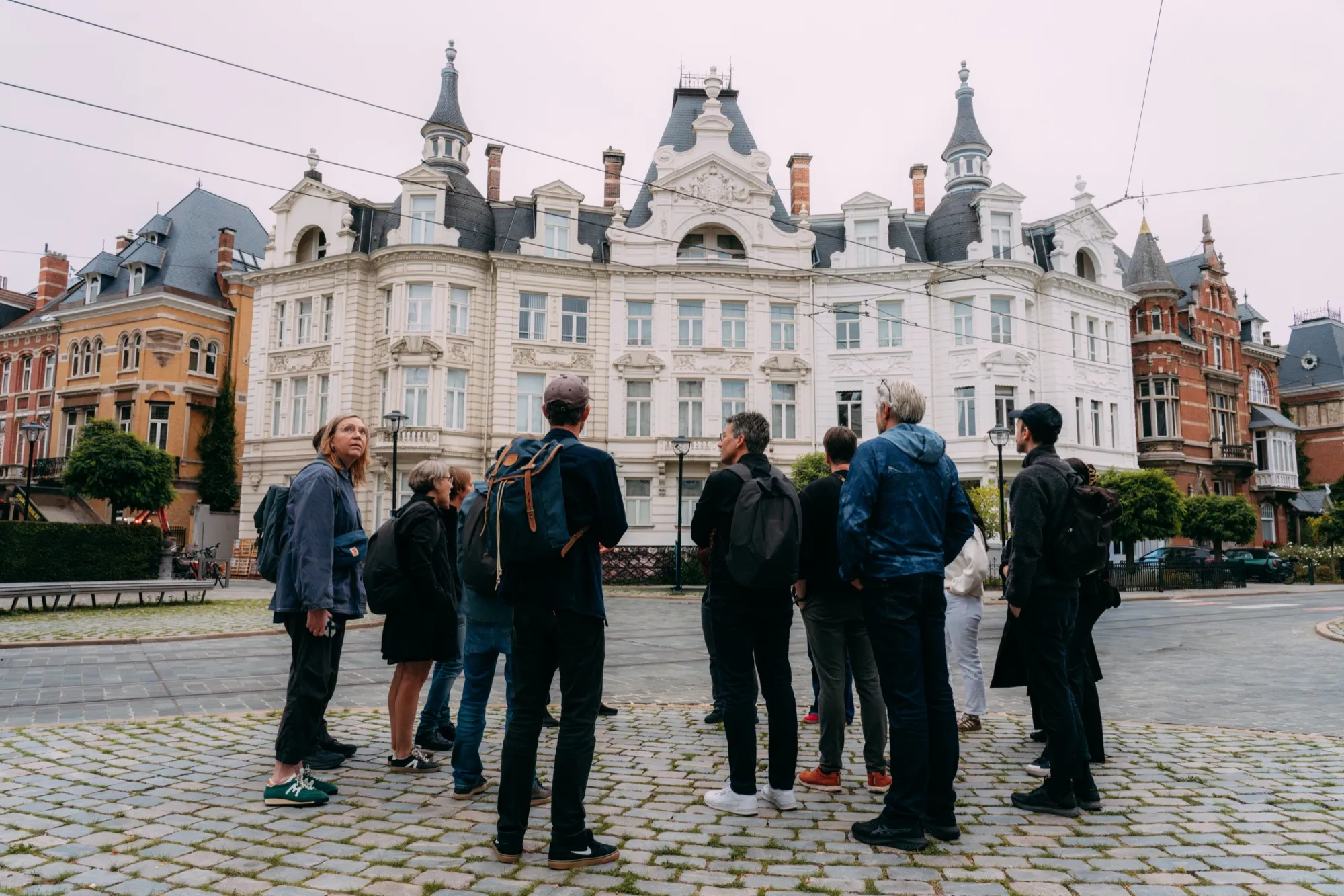 Een groep tijdens een rondleiding voor een historisch gebouw